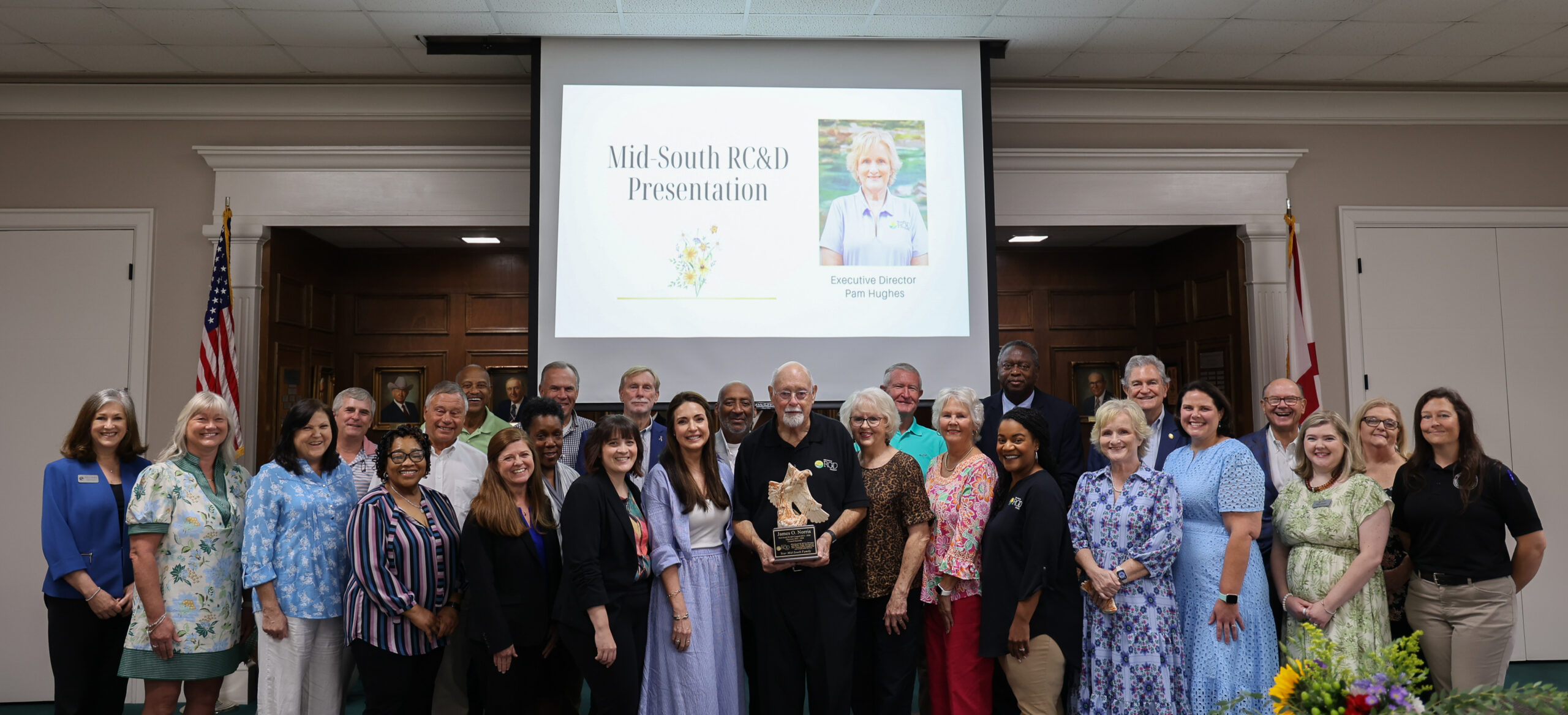 Group photo of Mid-South RC&D Council with Chairman in center holding award.